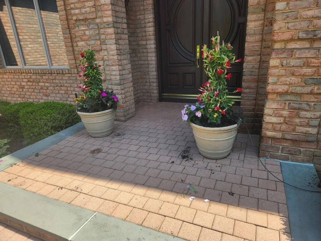 Flowering container planters flanking a brick front entrance